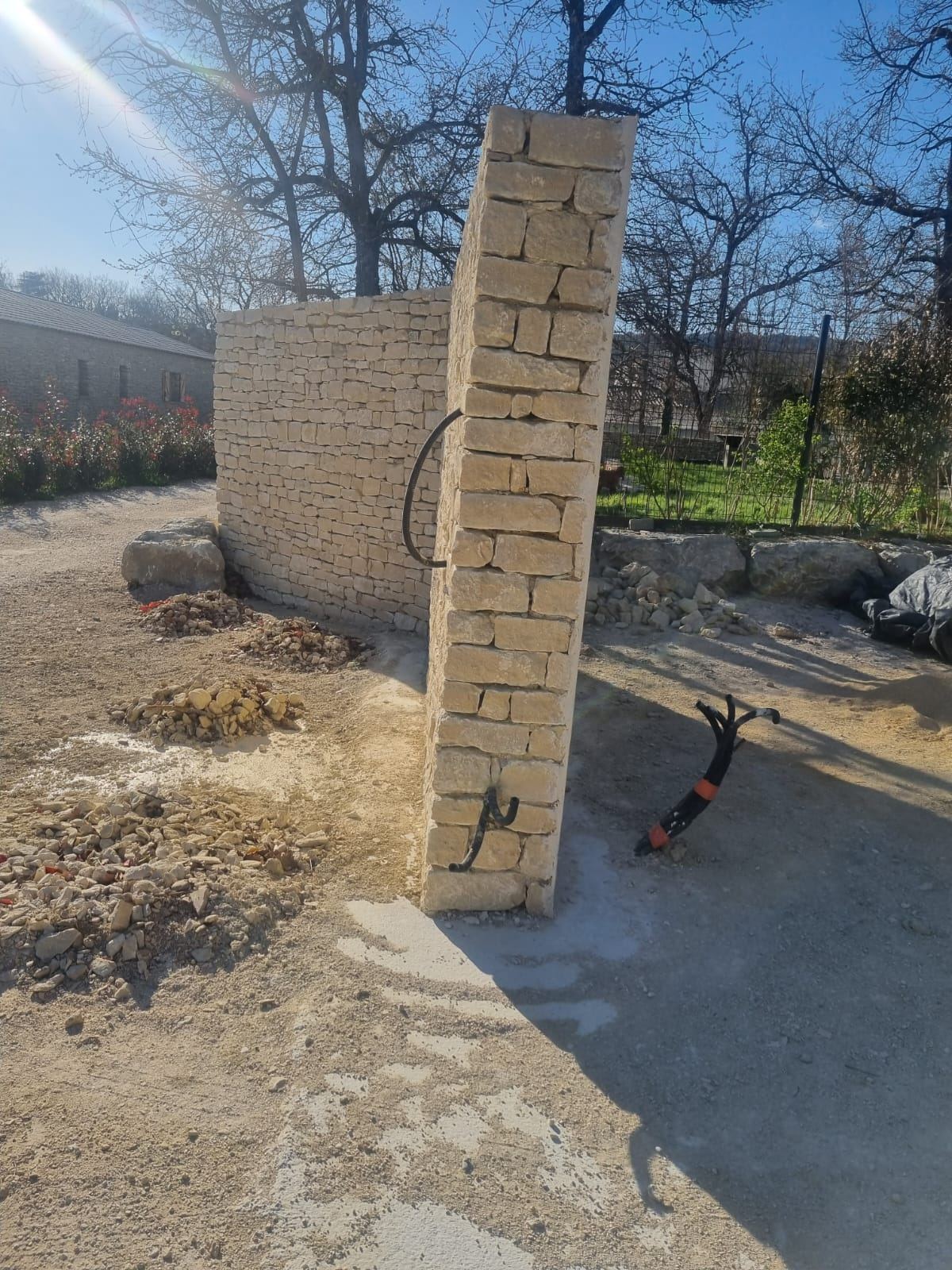 Pilier et mur en pierre naturelle en cours de construction